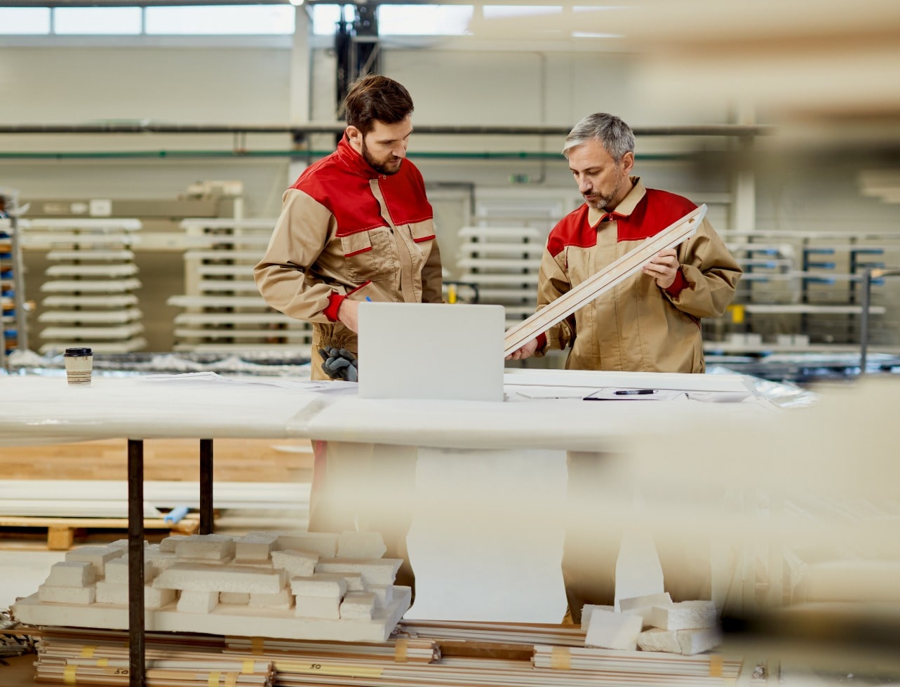 Vision Factory craftsmen reviewing precision woodworking designs at manufacturing facility